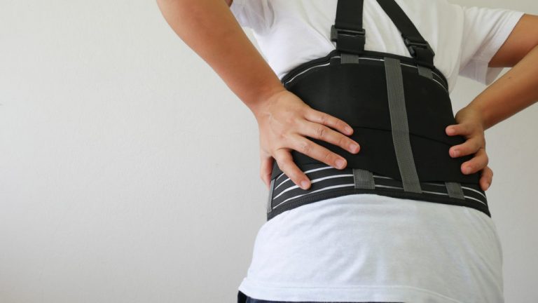 "Composite image showing lumbar spondylosis in the spine and a person using lumbar support for relief.