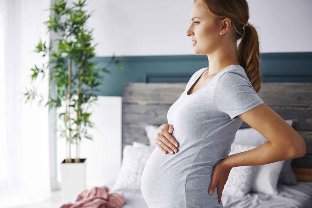 Pregnant woman receiving safe chiropractic care from a specialized prenatal chiropractor.