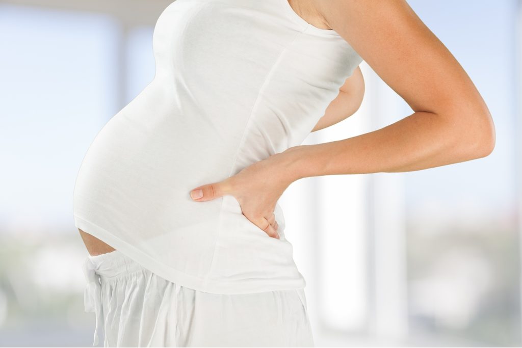 Pregnant woman consulting with a chiropractor about the right time for chiropractic care.
