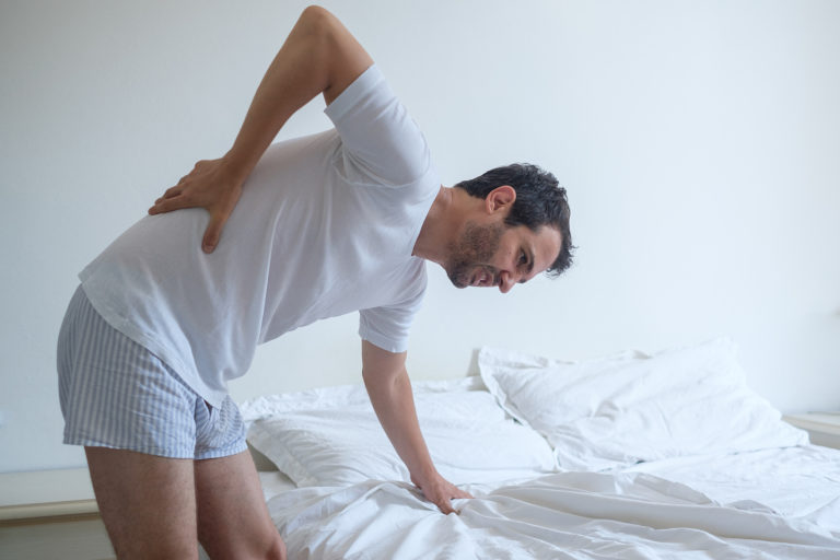 Illustration of the lumbar spine showing severe spinal arthritis and lumbar spinal stenosis leading to sciatica.