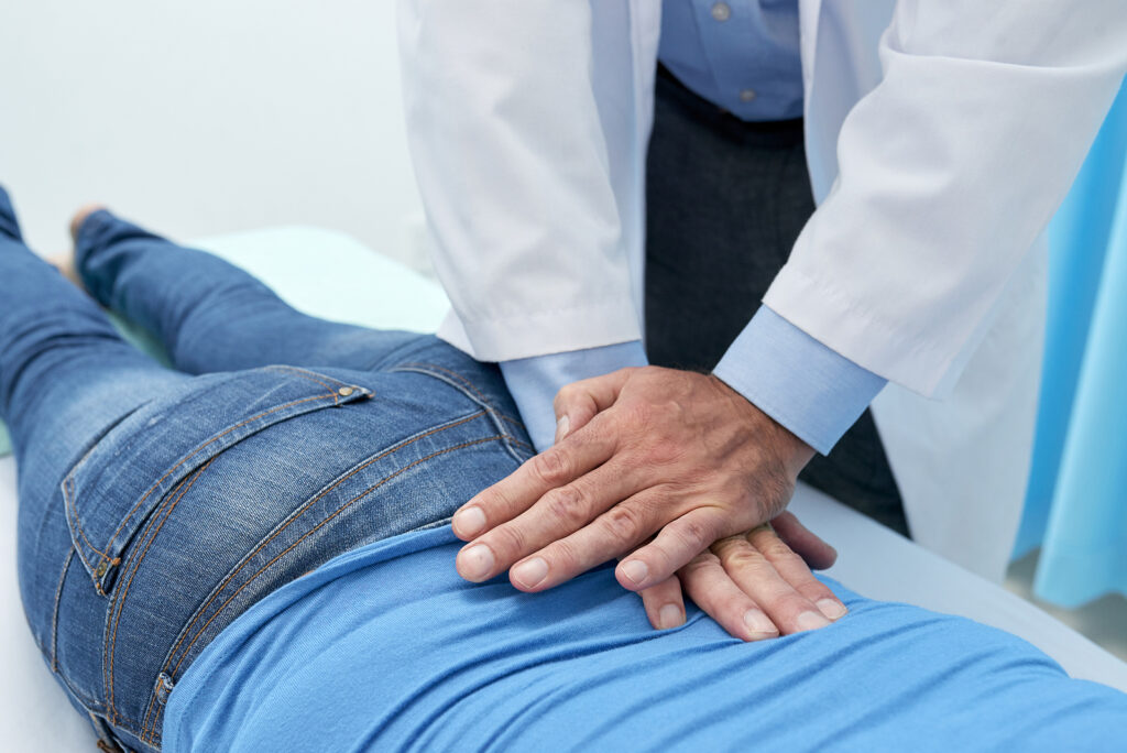 Chiropractor performing a spinal adjustment on a patient to restore joint mobility.